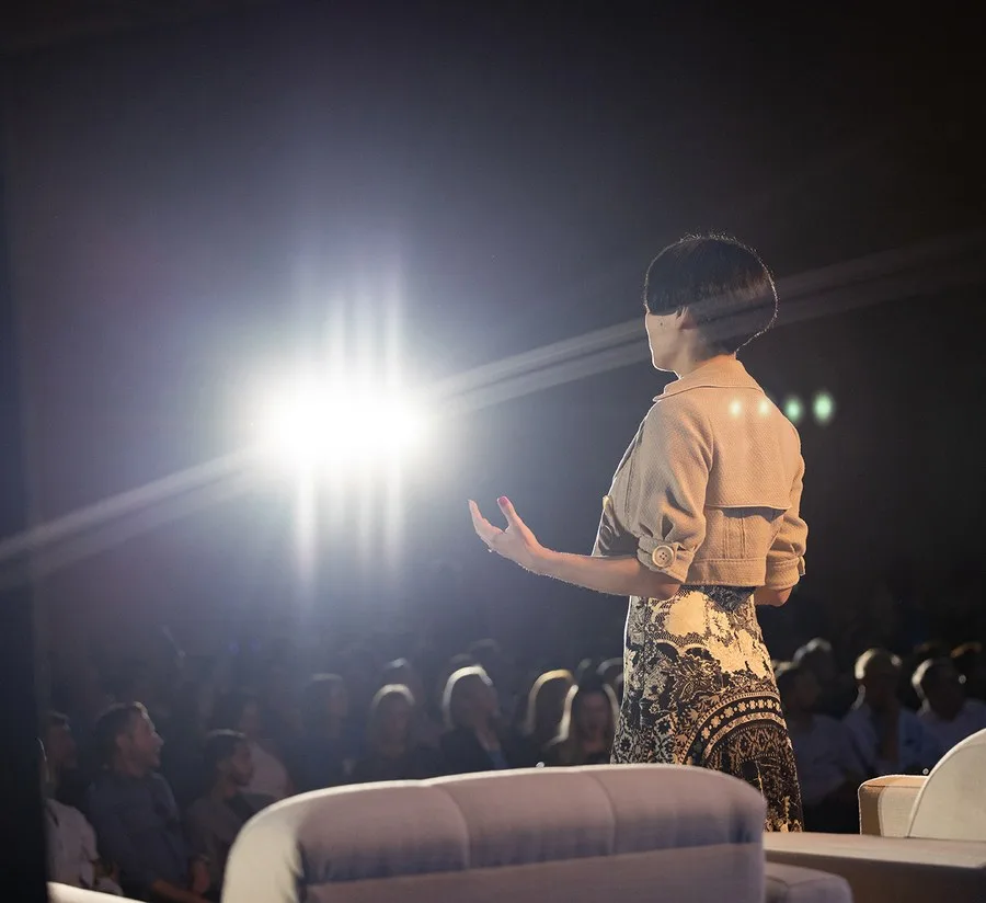 Drue Kataoka addressing a packed ballroom from the stage